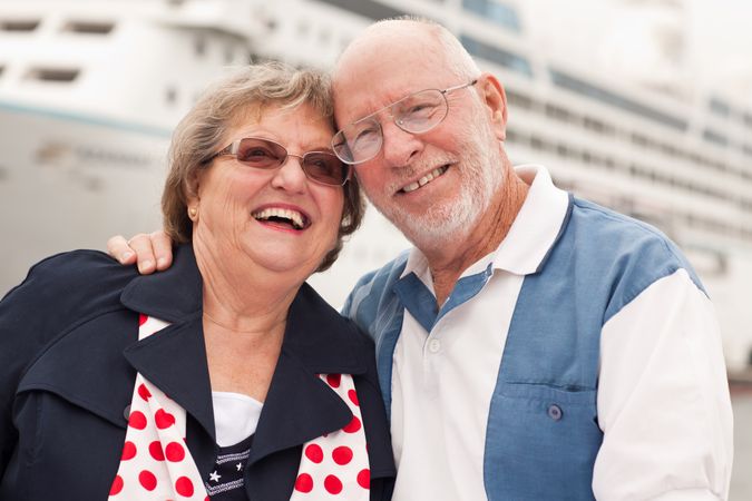 Older Couple On Shore in Front of Cruise Ship