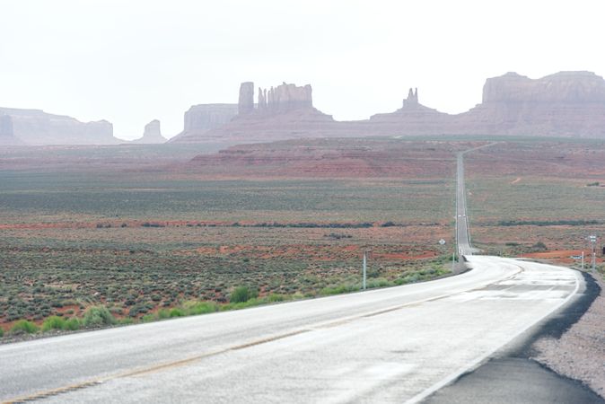 Asphalt road at scenic mountain valley and power line