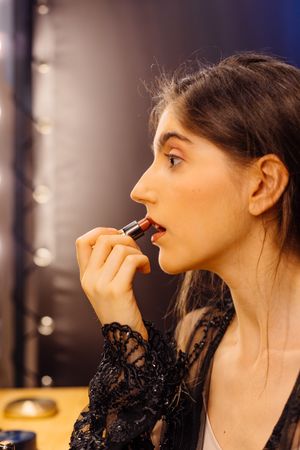 Glamorous female applying lipstick