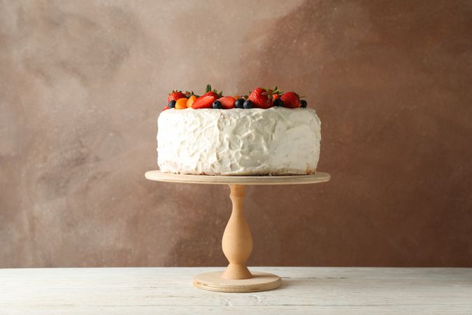 Berry cream cake on wooden table. Delicious dessert