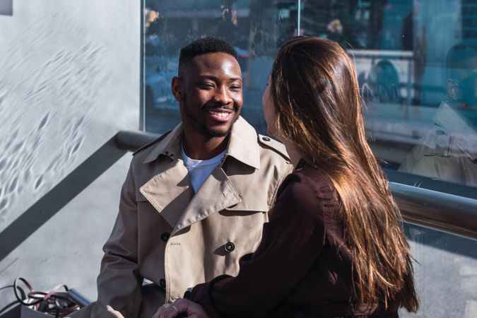 Romantic multiracial couple sitting on bus stop