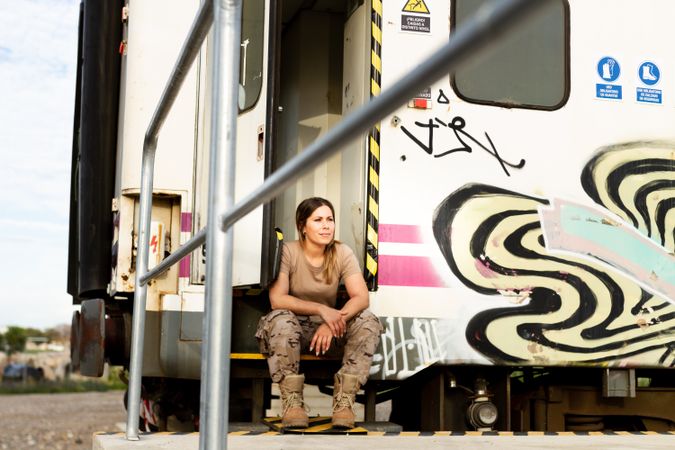 Military woman sitting near van