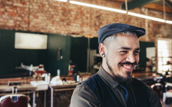 Close up of barber with cap looking away and smiling