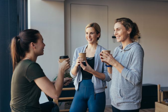 Three women relaxing with tea after a work out