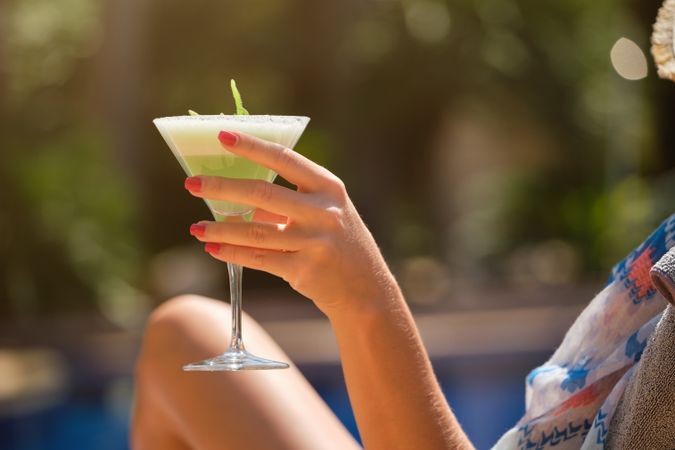 Crop woman with cocktail in hand