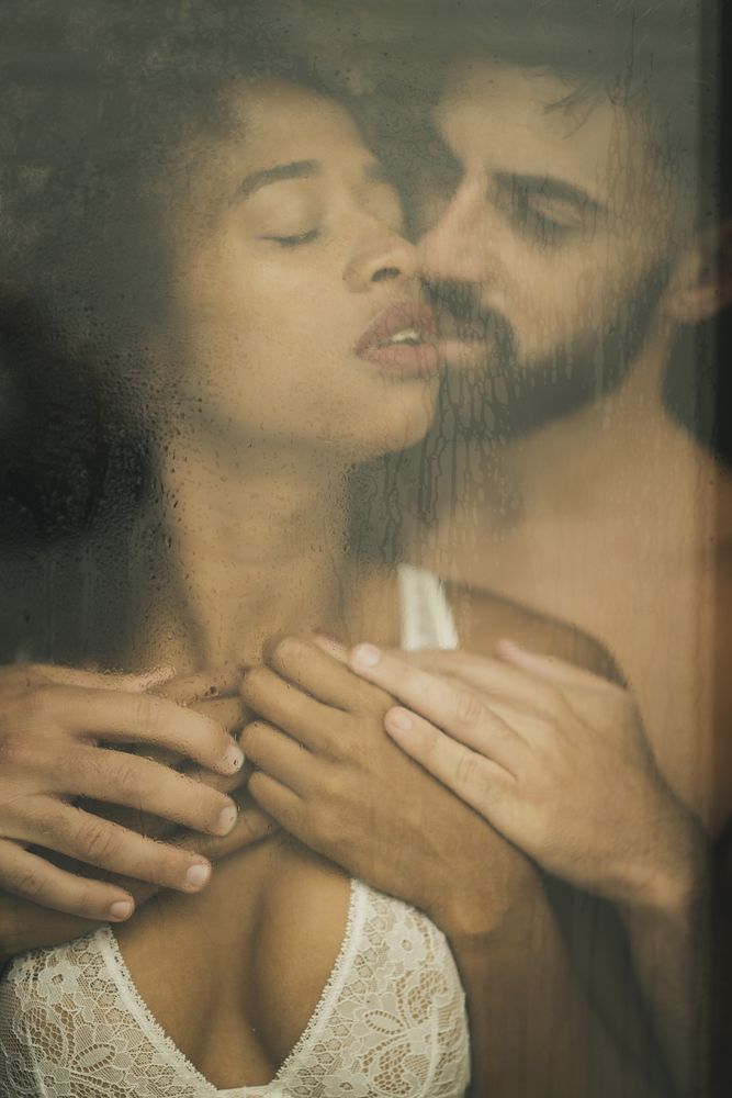 Bearded man touching girlfriend behind window