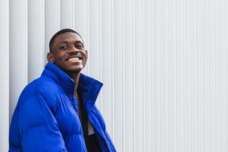 Black stylish man in warm jacket on street