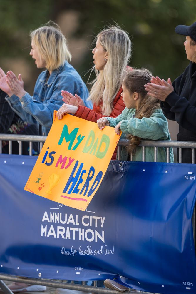 Diverse Group of People Running a Marathon in a City During the Day.
