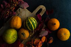 Top view of autumn squash on rustic breadboard and leaves