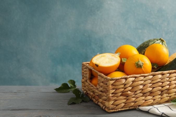 Basket with zucchini on napkin on wooden table