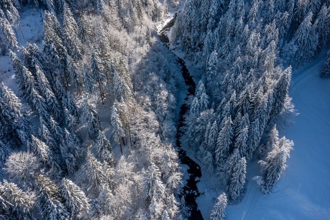 River flowing in the deep snow forest, aerial view in the Bavarian Alps, Germany