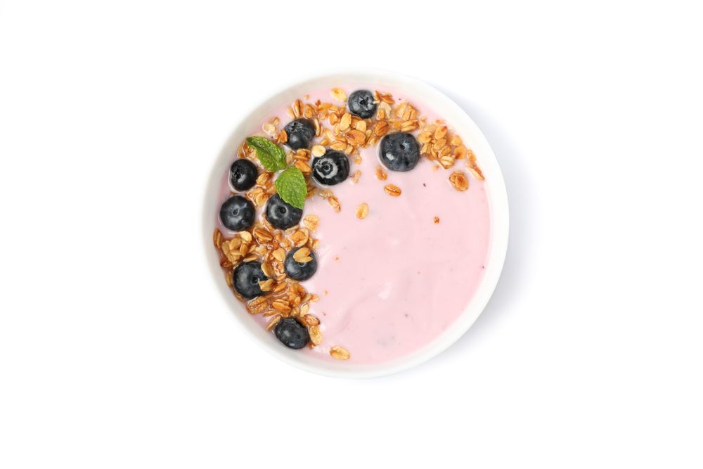 Yogurt with granola, blueberry and mint isolated on blank background