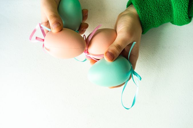 Hands holding pastel egg decorations