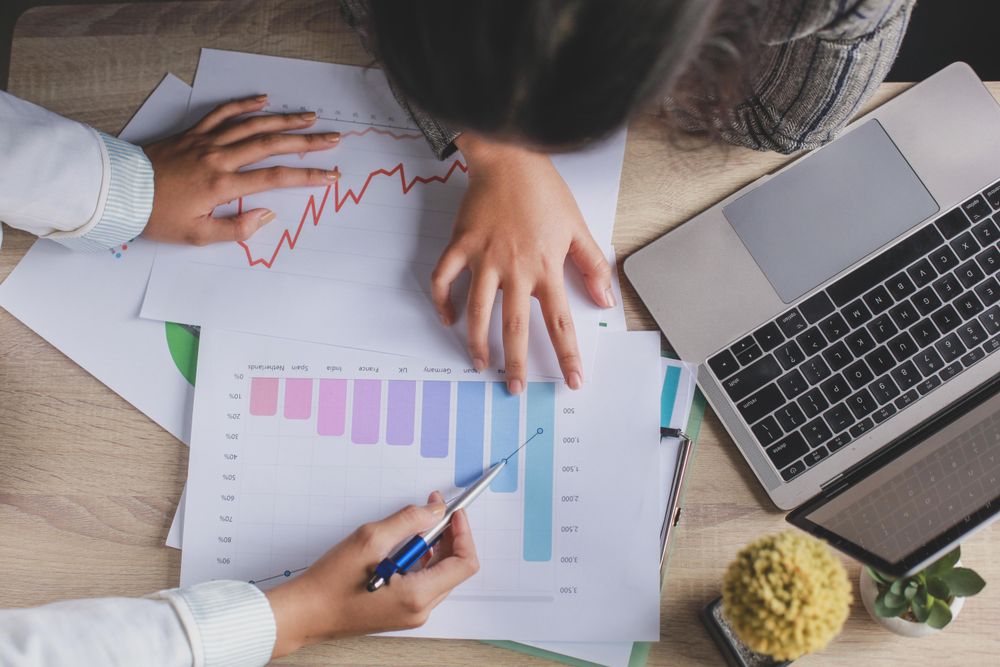 Two people discussing bar charts in an office