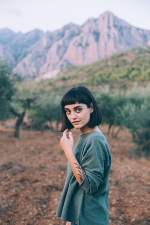 Woman in beautiful park with hills and olive trees
