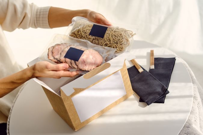 Woman with delivered ingredients for ramen