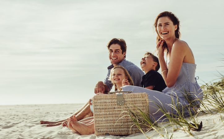Family sitting on the beach having fun