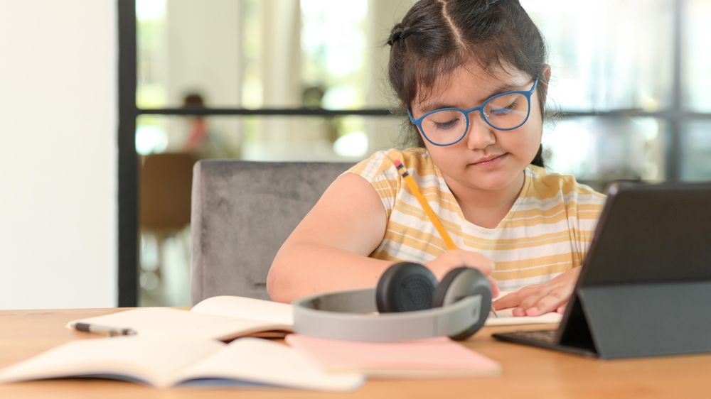 Asian girl wearing glasses and studying online