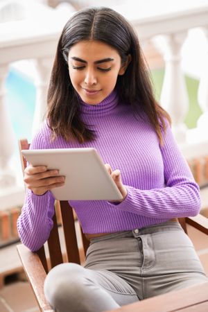 Female sitting on deck with tablet