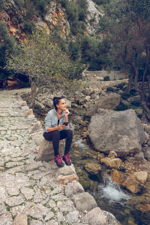 Traveling female with phone near river