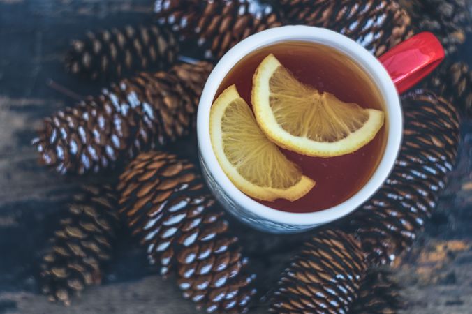 Christmas card concept of cup of tea surrounded by pine cones