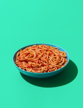 Spaghetti Pomodoro dish isolated on a green background
