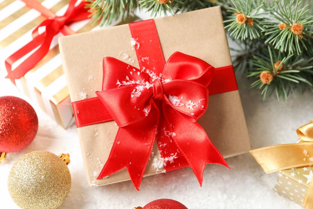 Gift box with bow on decorated background, close up