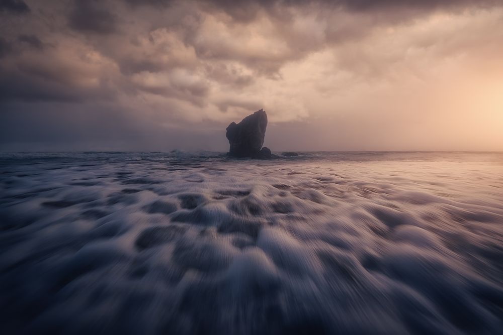 Coastal rock on beach and overcast sky