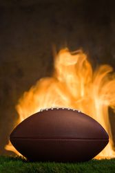 American football ball with fire at the background