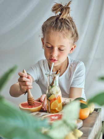 Boy squeezing pomelo while making drink