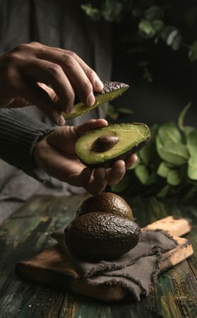 Person hands holding avocados