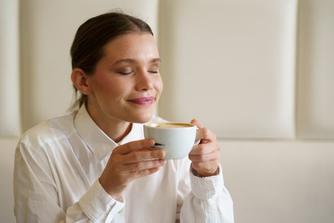 Woman enjoying a latte in a modern cafeteria