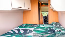 Bed with green linen inside of empty motorhome 5w2DW0