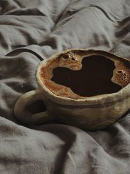Coffee cup on grey bed