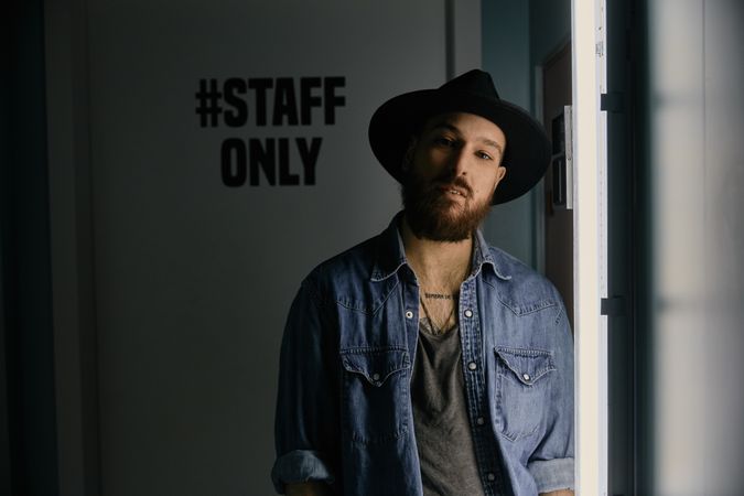 man in hat looking at camera in room