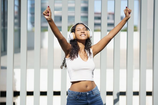 A Joyful Young Woman is Enjoying Music While in an Urban Setting Full of Life and Energy