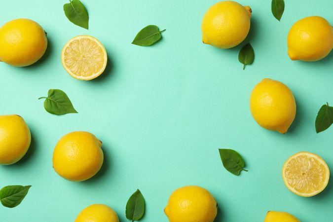 Fresh lemons on mint background, top view. Ripe fruit