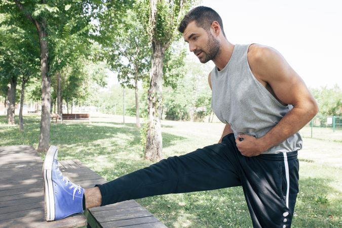 Sportsman stretching body in park