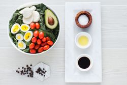 Spinach salad with eggs avocados tomatoes and mozzarella cheese