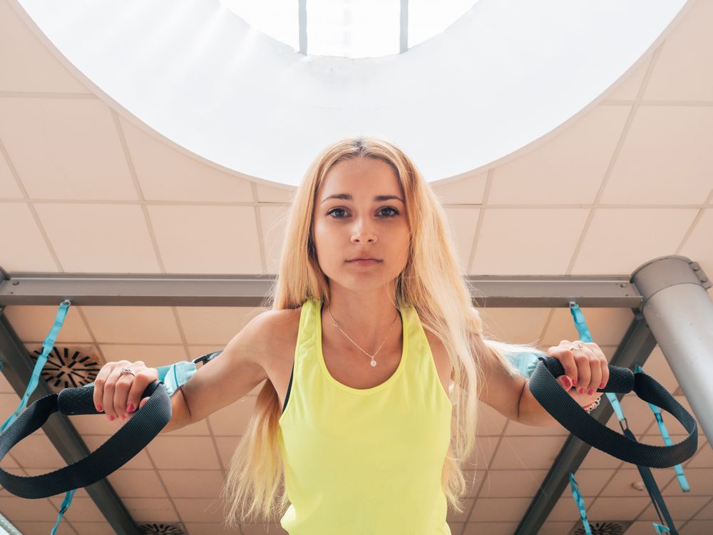 Young female having suspension training