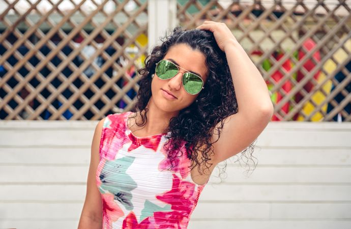 Smiling woman standing outside in pink shirt and sunglasses