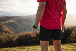 Male runner resting and enjoying mountain landscape