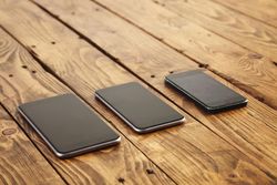 Three different sized phones on table