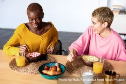 Two multi-ethnic girlfriends having breakfast together at home 5r6d15
