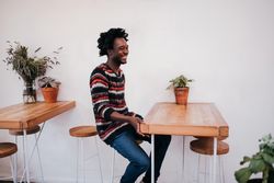 Smiling man sitting at restaurant table with plants
