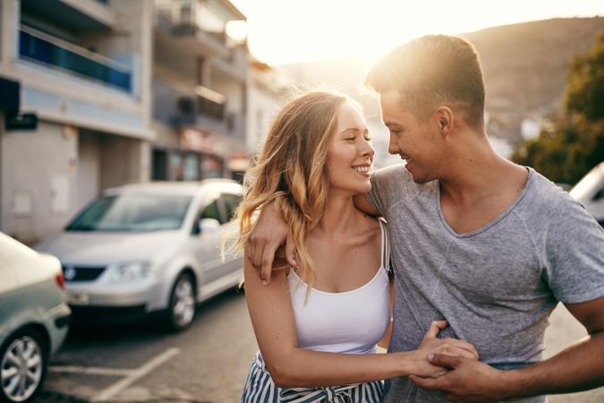 Cute couple embracing each other while walking down the street
