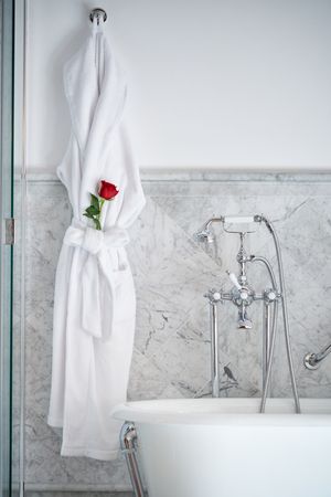 Interior of bathroom with bathrobe with fresh red rose