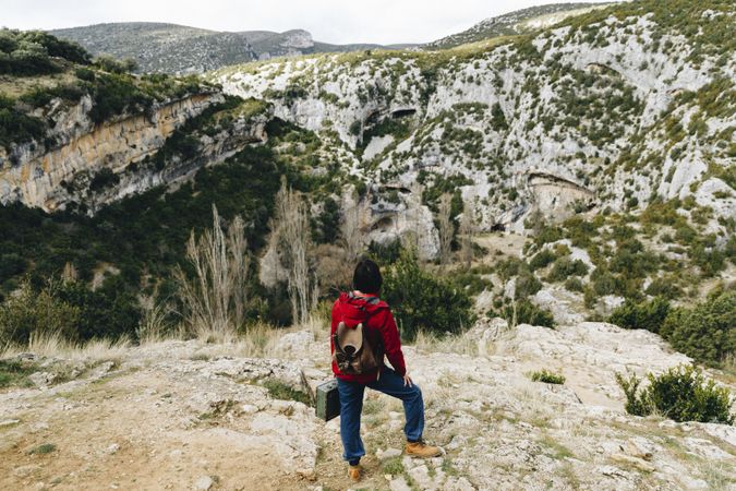 Woman with backpack on high cliff