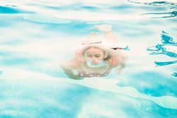 Happy teenager emerging from pool water