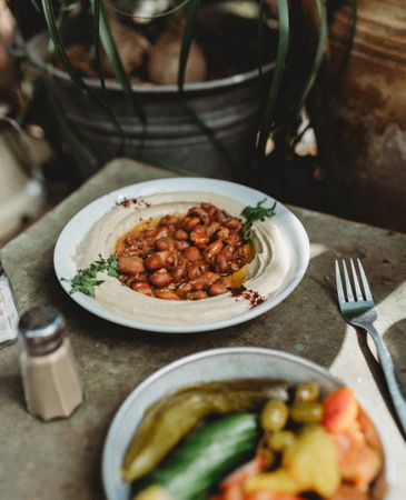 beans hummus in plate close to vegetables plate